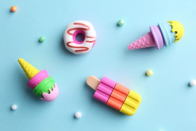 Photo of Toy ice creams, donut and beads on light blue background, flat lay