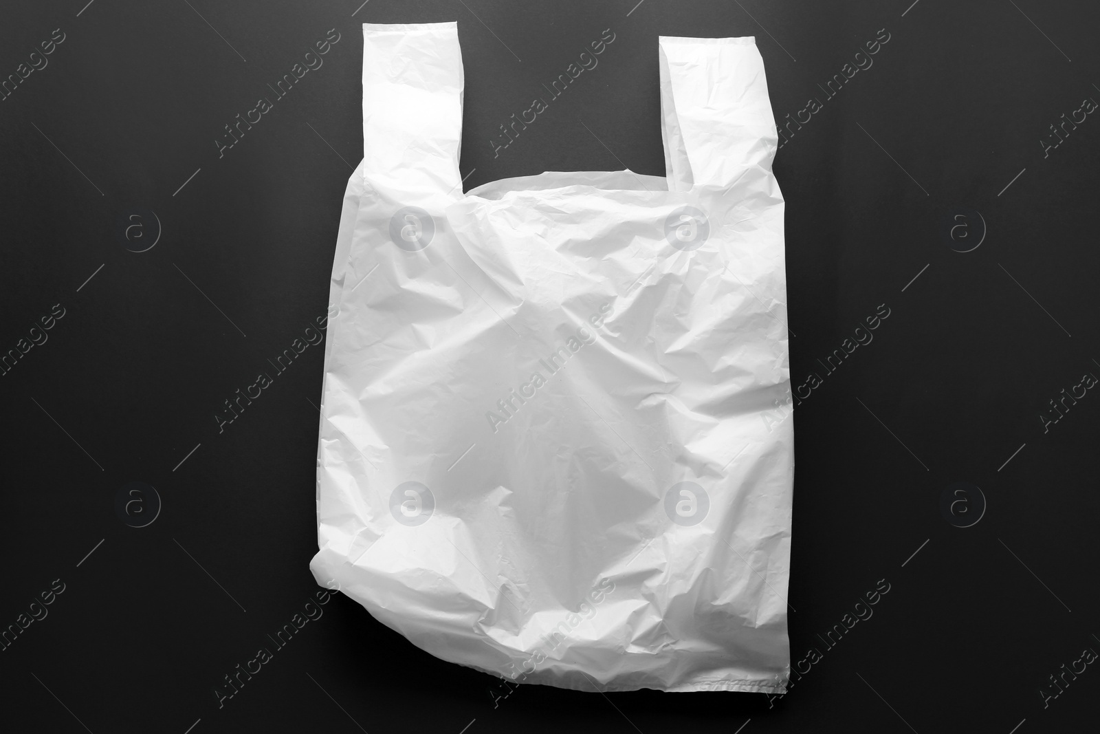 Photo of Clear disposable plastic bag on black background