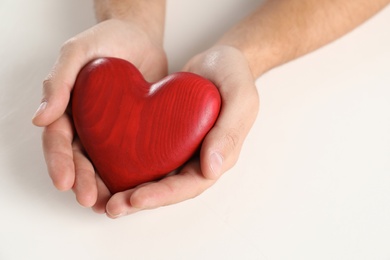 Photo of Man holding decorative heart on white background, closeup