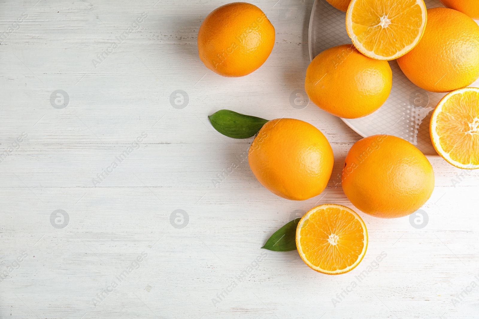 Photo of Flat lay composition with fresh oranges on wooden table. Space for text