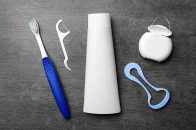 Photo of Flat lay composition with tongue cleaner and teeth care products on grey background