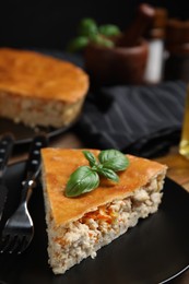Photo of Piece of delicious pie with meat and basil in plate, closeup