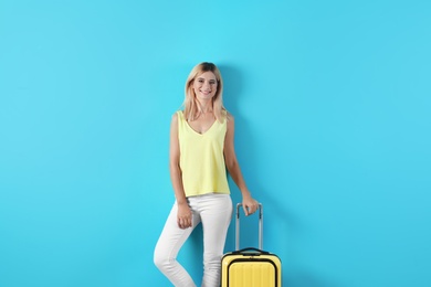 Photo of Woman with suitcase on color background. Vacation travel