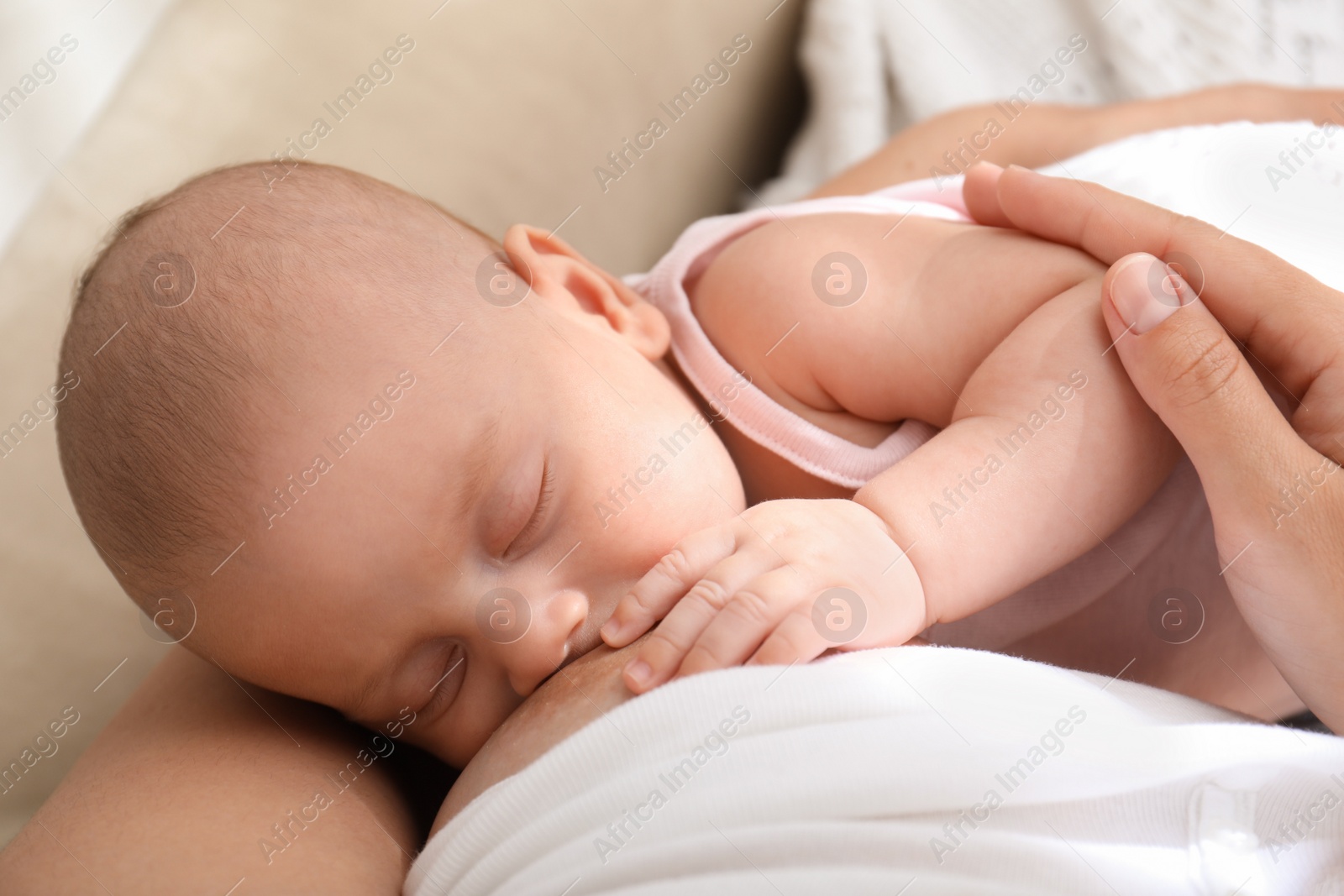 Photo of Young woman breastfeeding her little baby at home, above view