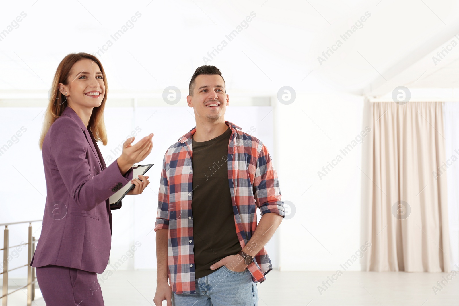 Photo of Real estate agent showing new apartment to client. Space for text