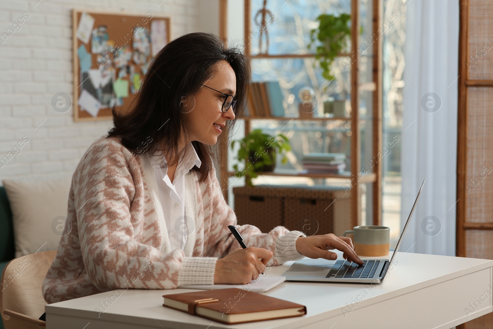 Photo of Woman with modern laptop learning at home