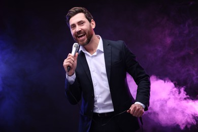 Photo of Emotional man with microphone singing in neon lights