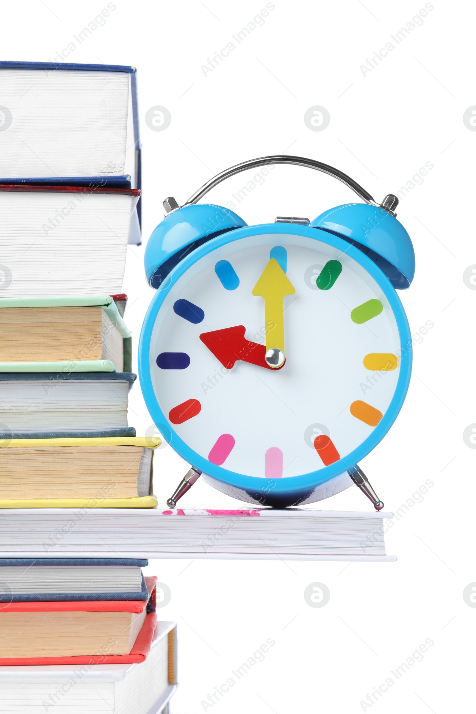 Photo of Light blue alarm clock and different books on white background. School time