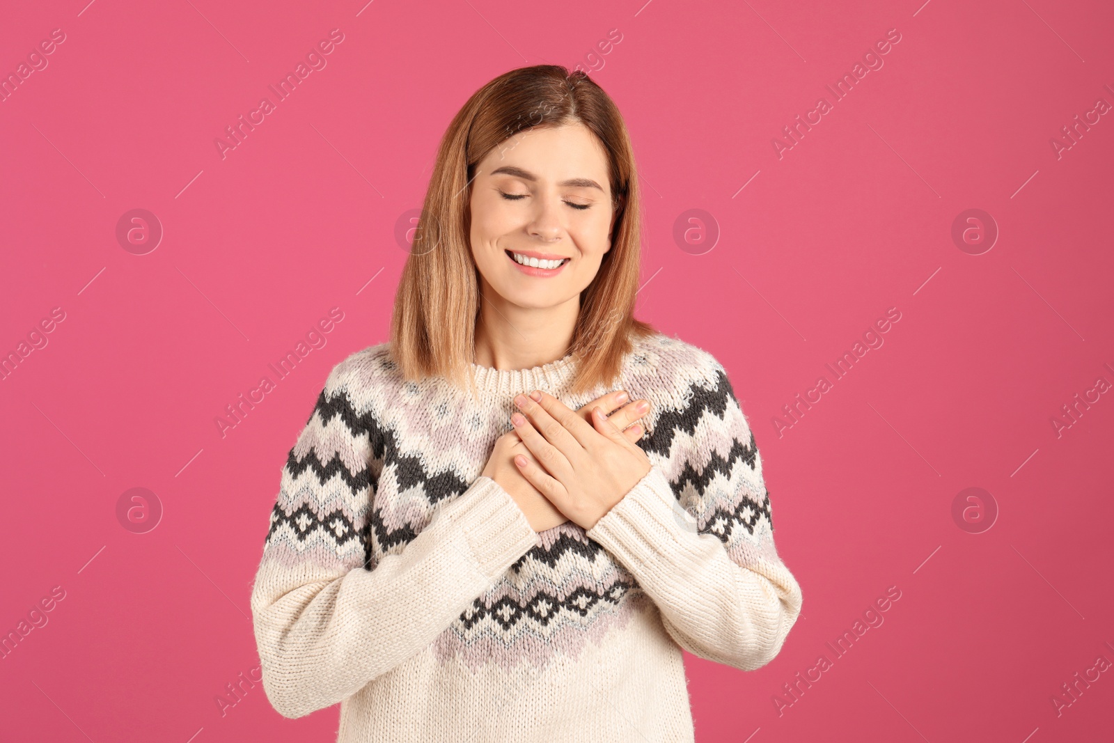 Photo of Portrait of woman holding hands near heart on color background