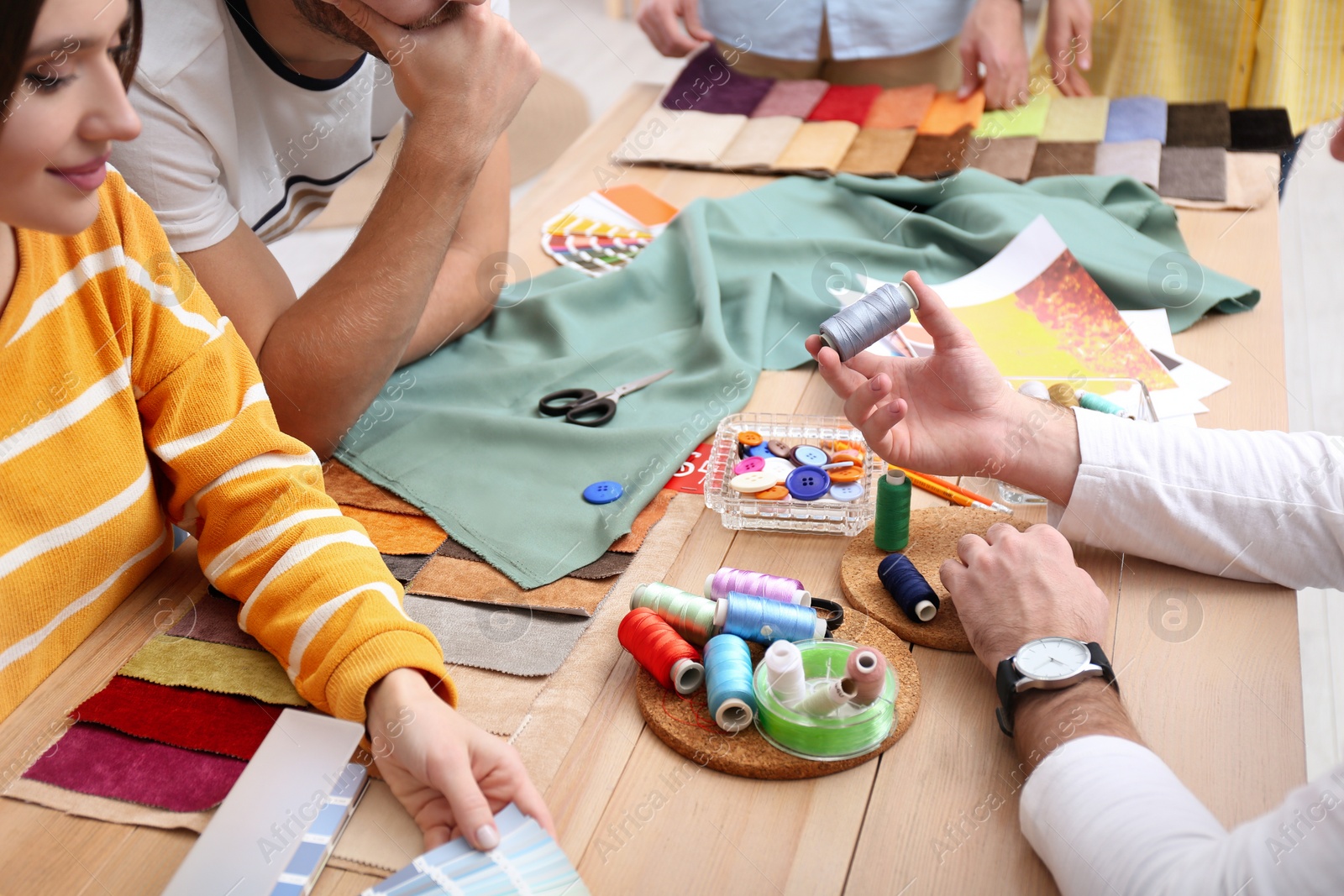 Photo of Fashion designers creating new clothes in studio, closeup