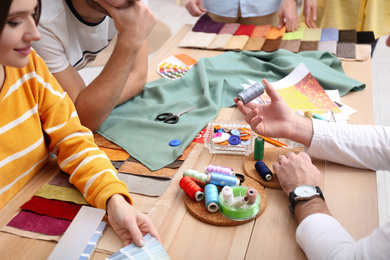 Photo of Fashion designers creating new clothes in studio, closeup