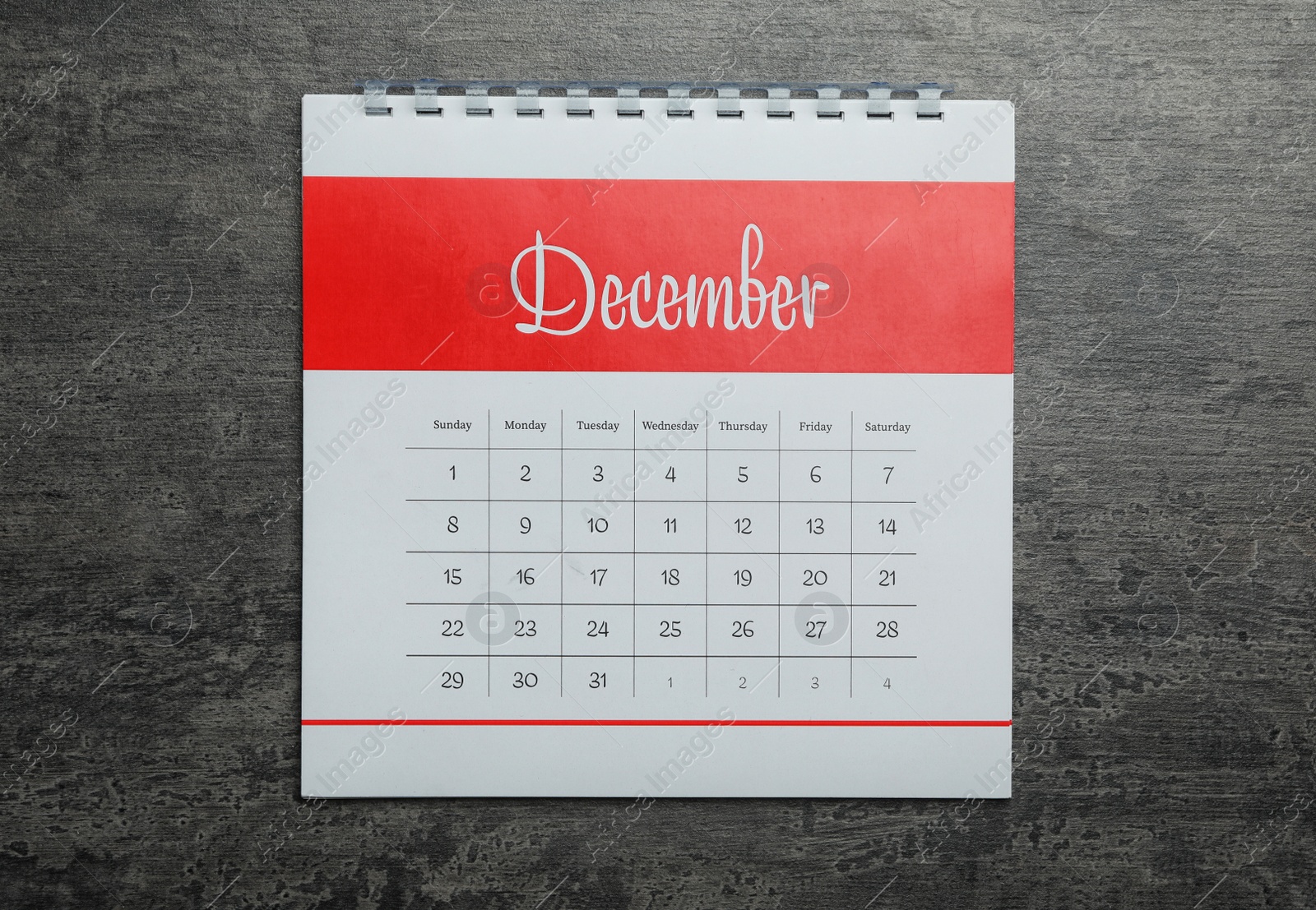 Photo of December calendar on grey stone background, top view