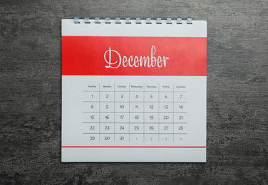 Photo of December calendar on grey stone background, top view