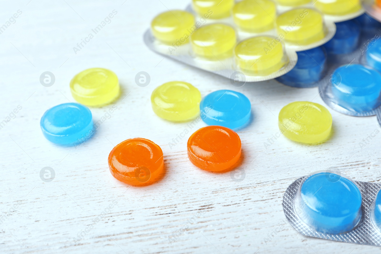 Photo of Color cough drops on white wooden background