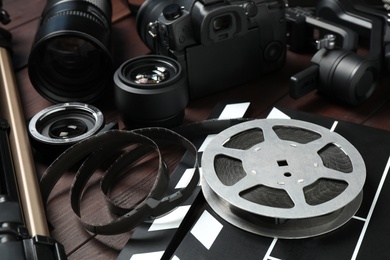 Photo of Modern camera and video production equipment on brown wooden table, closeup