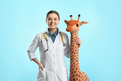 Pediatrician with toy giraffe and stethoscope on turquoise background