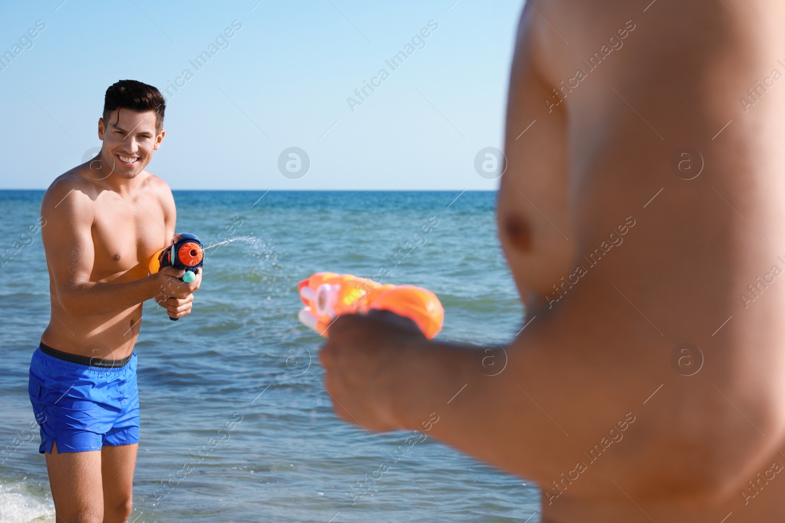 Photo of Friends with water guns having fun in sea