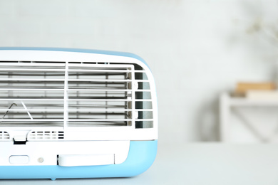 Photo of Modern air purifier on white table in room, closeup
