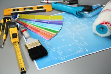 Photo of Set of decorator's tools and project drawing on grey background