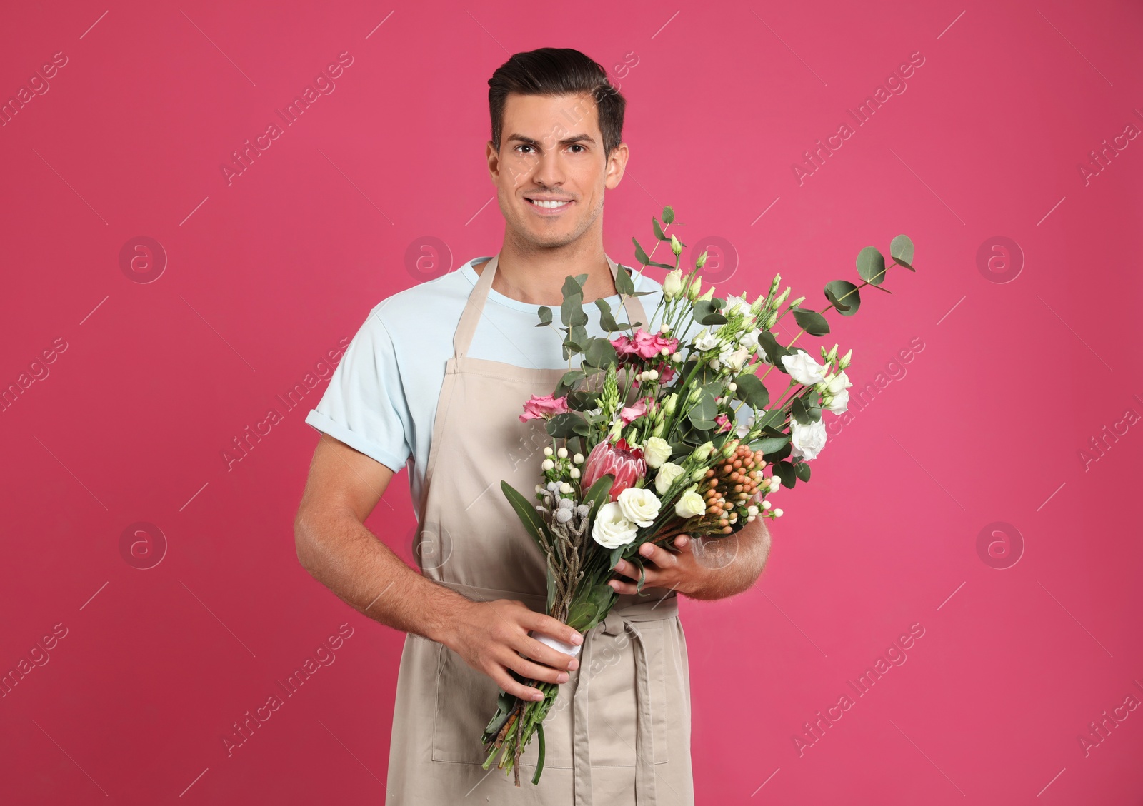 Photo of Florist with beautiful bouquet on pink background