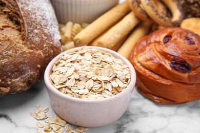 Photo of Different gluten free products on white marble table, closeup