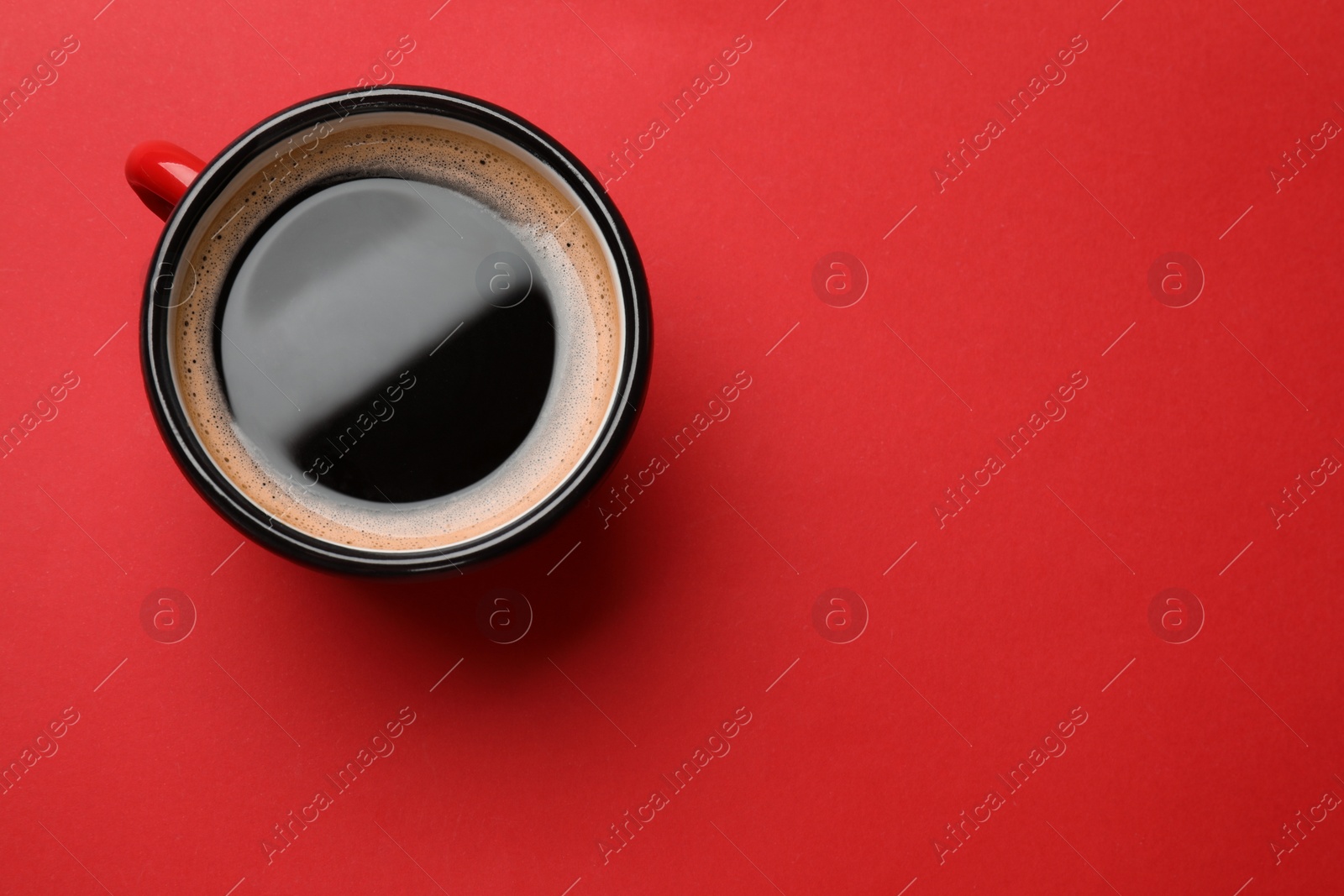 Photo of Fresh coffee in cup on red background, top view. Space for text