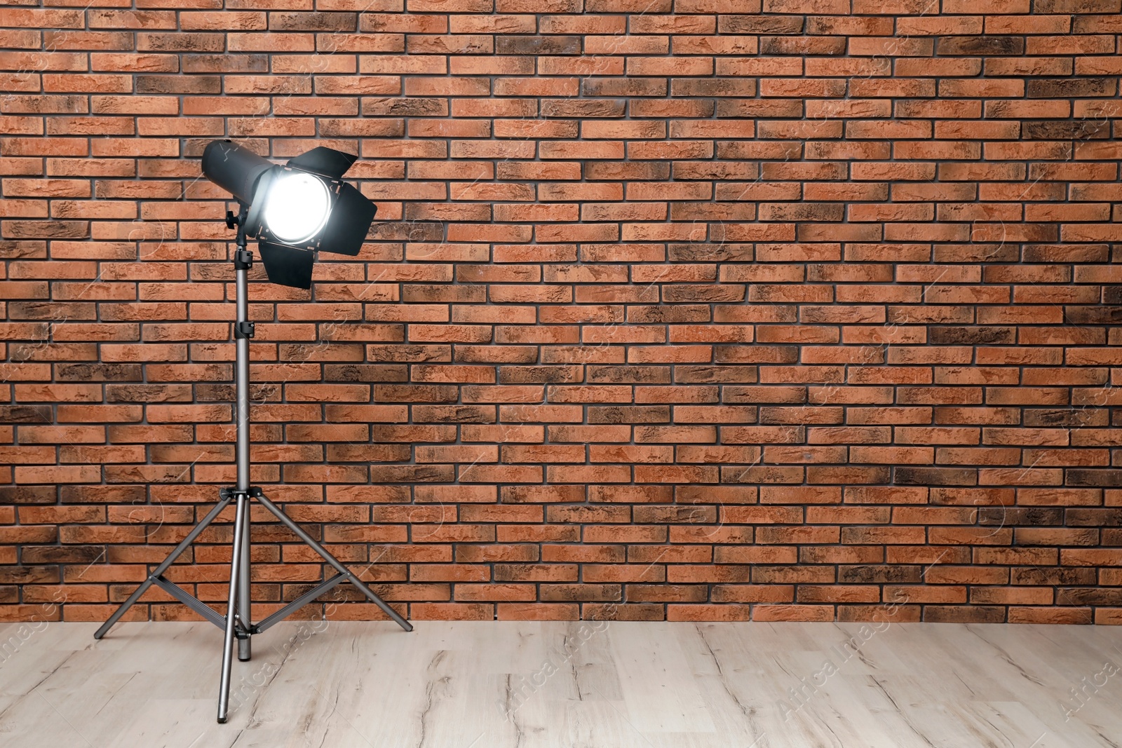 Photo of Professional lighting equipment near wall in photo studio. Space for text