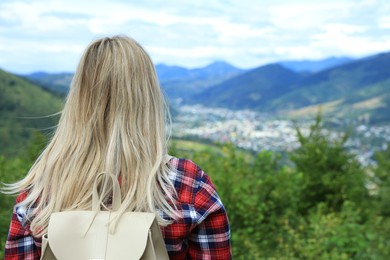 Woman enjoying beautiful mountain landscape, back view