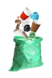 Image of Different garbage falling into trash bag on white background