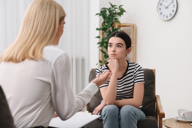 Psychologist working with teenage girl in office