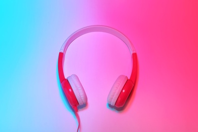 Photo of Stylish headphones on color background, top view