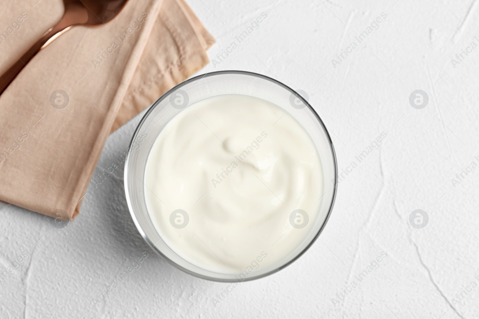 Photo of Bowl with yummy yogurt on light background