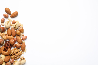 Different delicious nuts on white background, flat lay. Space for text