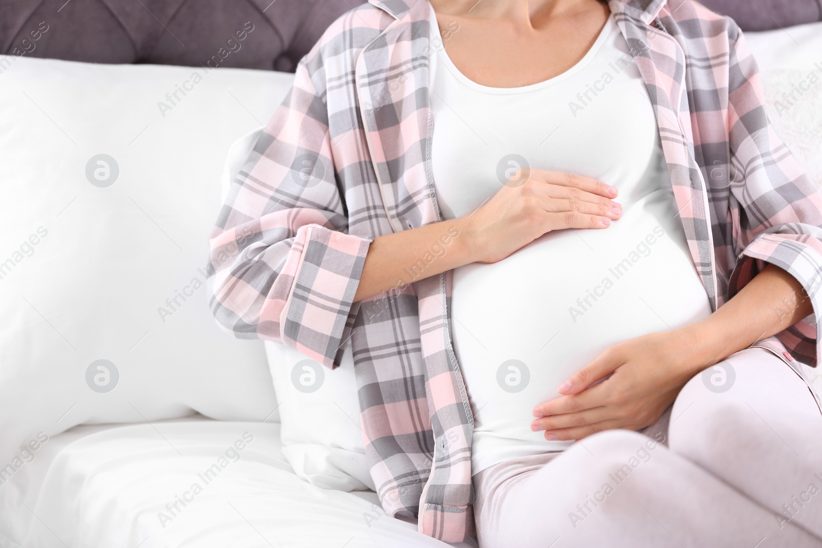 Photo of Happy pregnant woman lying in bed at home, closeup