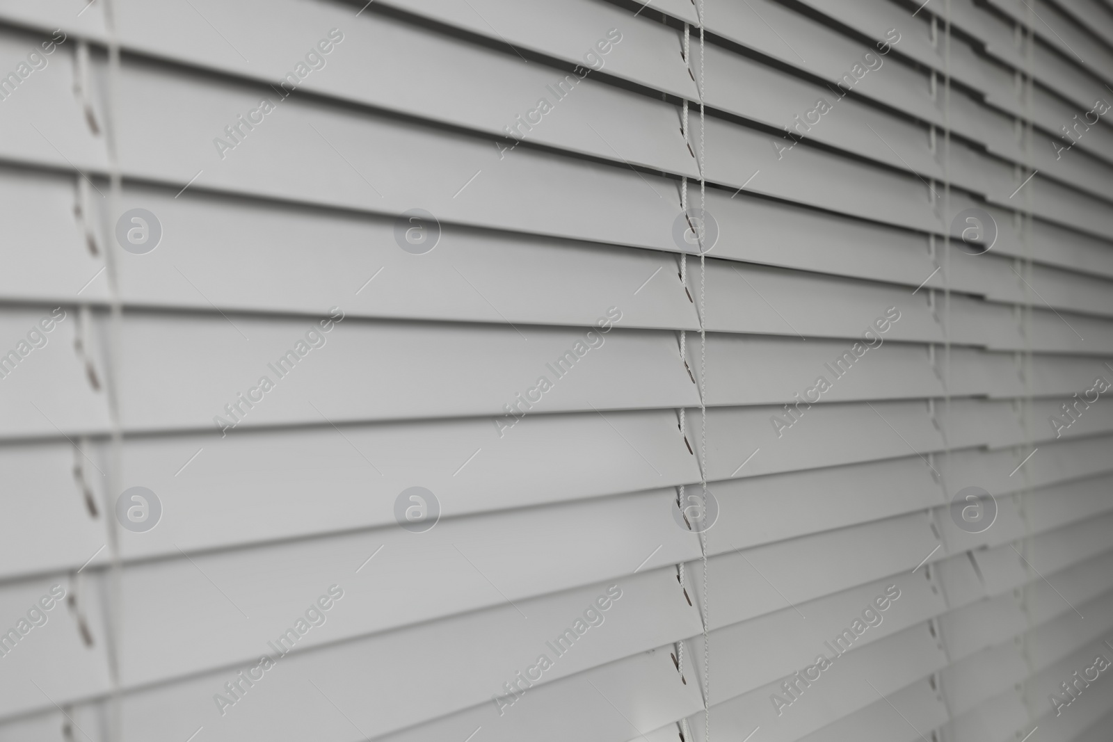 Photo of Closeup view of horizontal blinds on window indoors