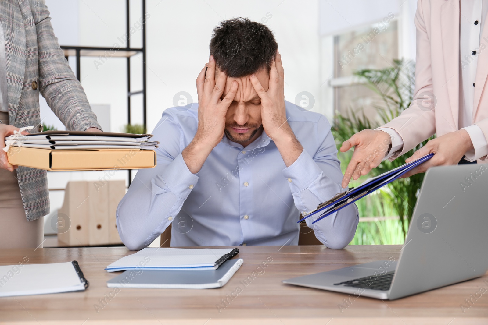 Photo of Businessman stressing out at workplace in office