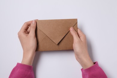 Photo of Woman with letter envelope at white table, top view