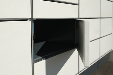 Photo of Modern parcel locker with open box, closeup view