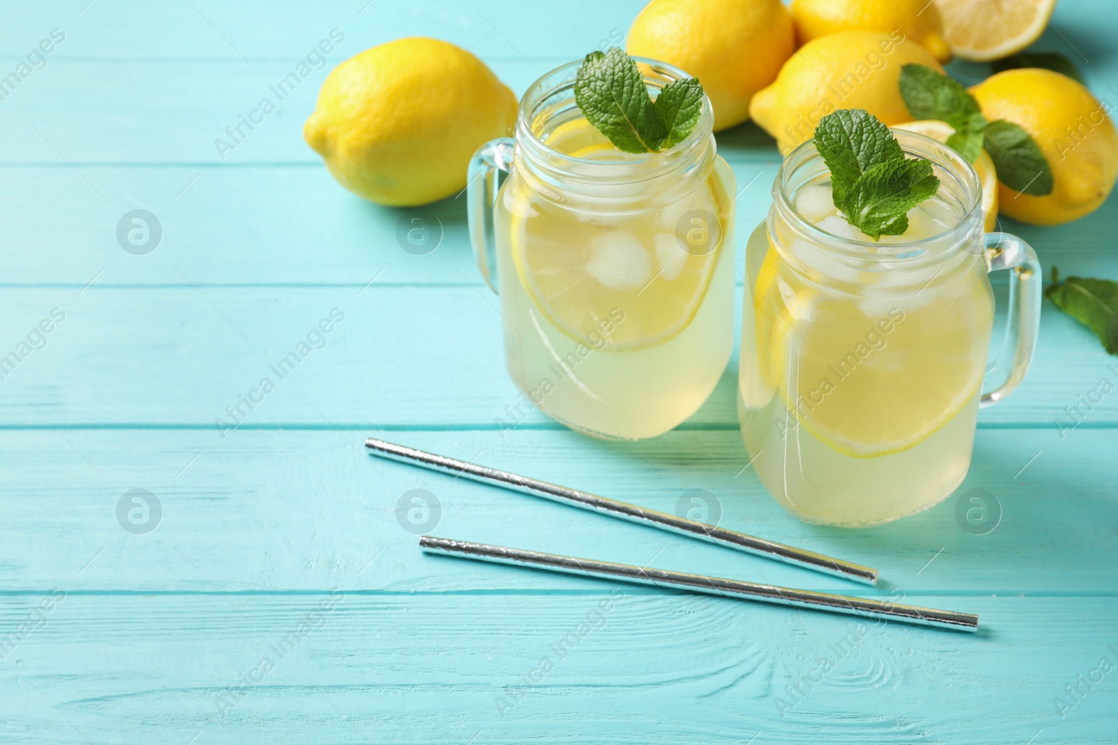 Photo of Natural lemonade with mint on light blue wooden table, space for text. Summer refreshing drink