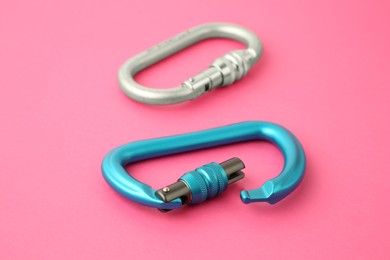 Photo of Two metal carabiners on bright pink background