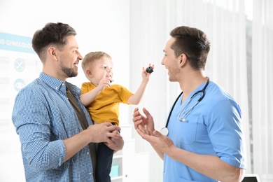 Photo of Father with child visiting doctor in hospital