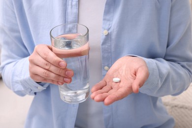 Photo of Woman with glass of water and pill, closeup