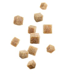 Brown cane sugar cubes falling on white background