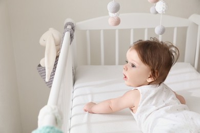 Cute little baby lying in comfortable crib at home