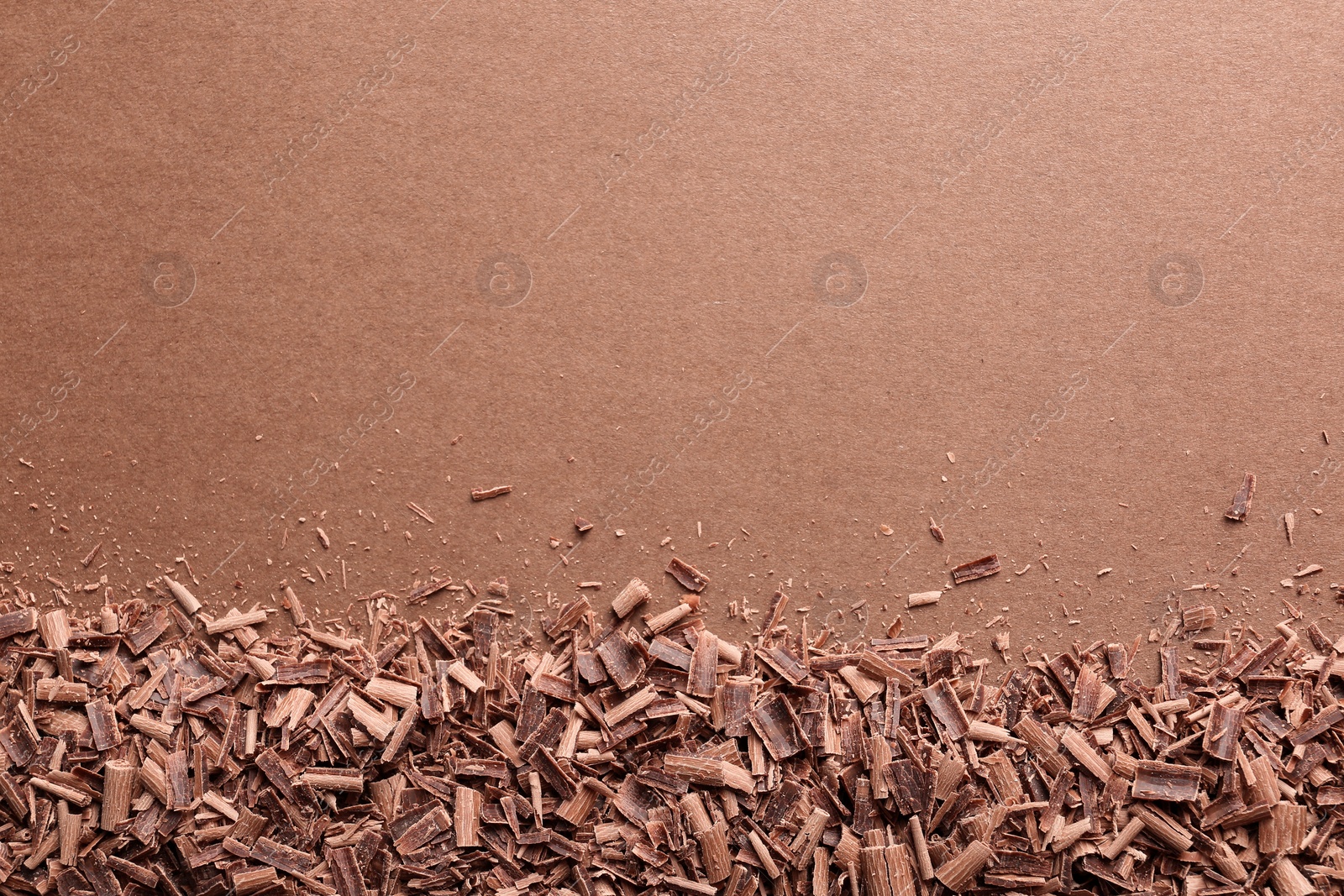 Photo of Chocolate curls and space for text on color background, top view