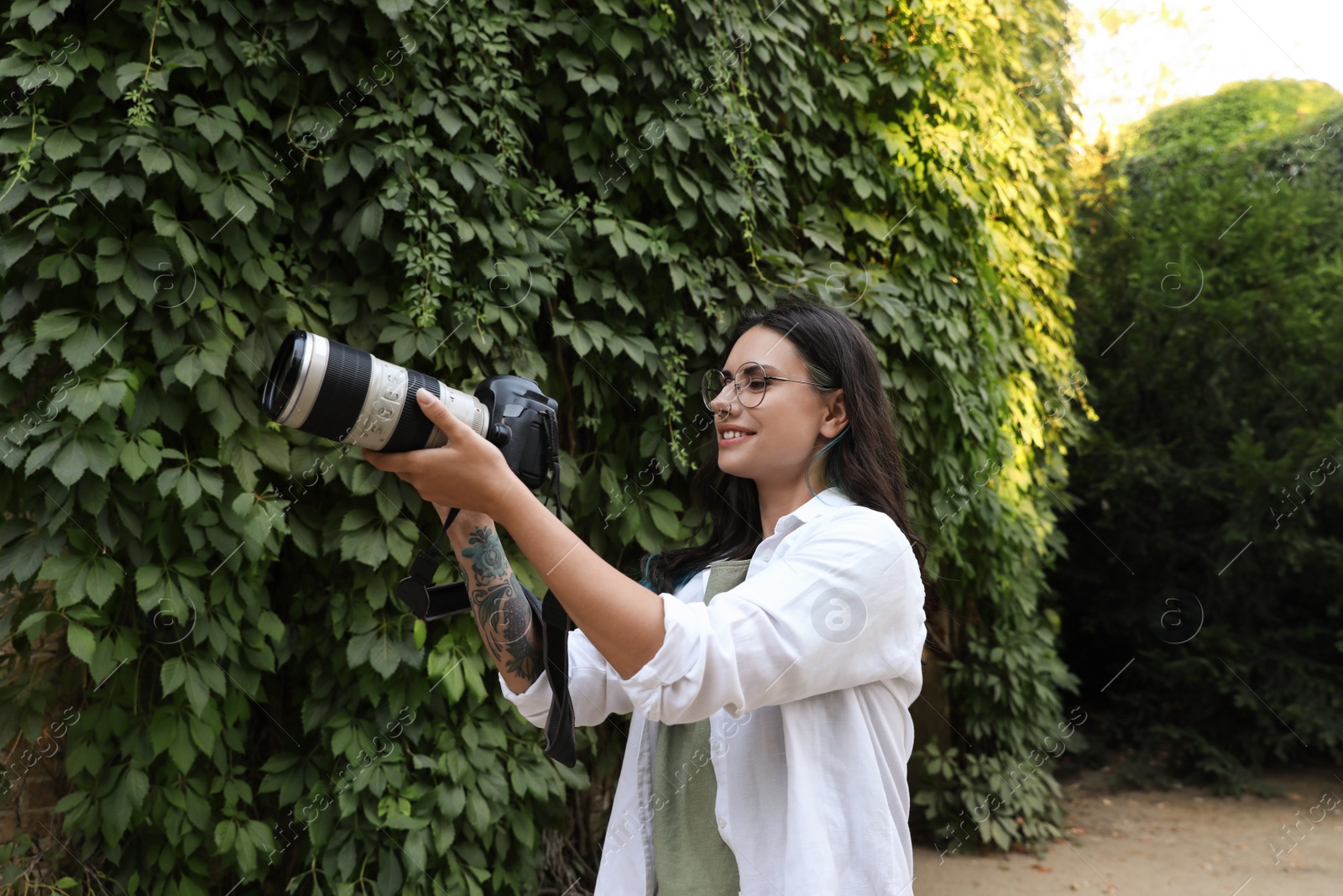 Photo of Beautiful woman with camera spending time in nature reserve