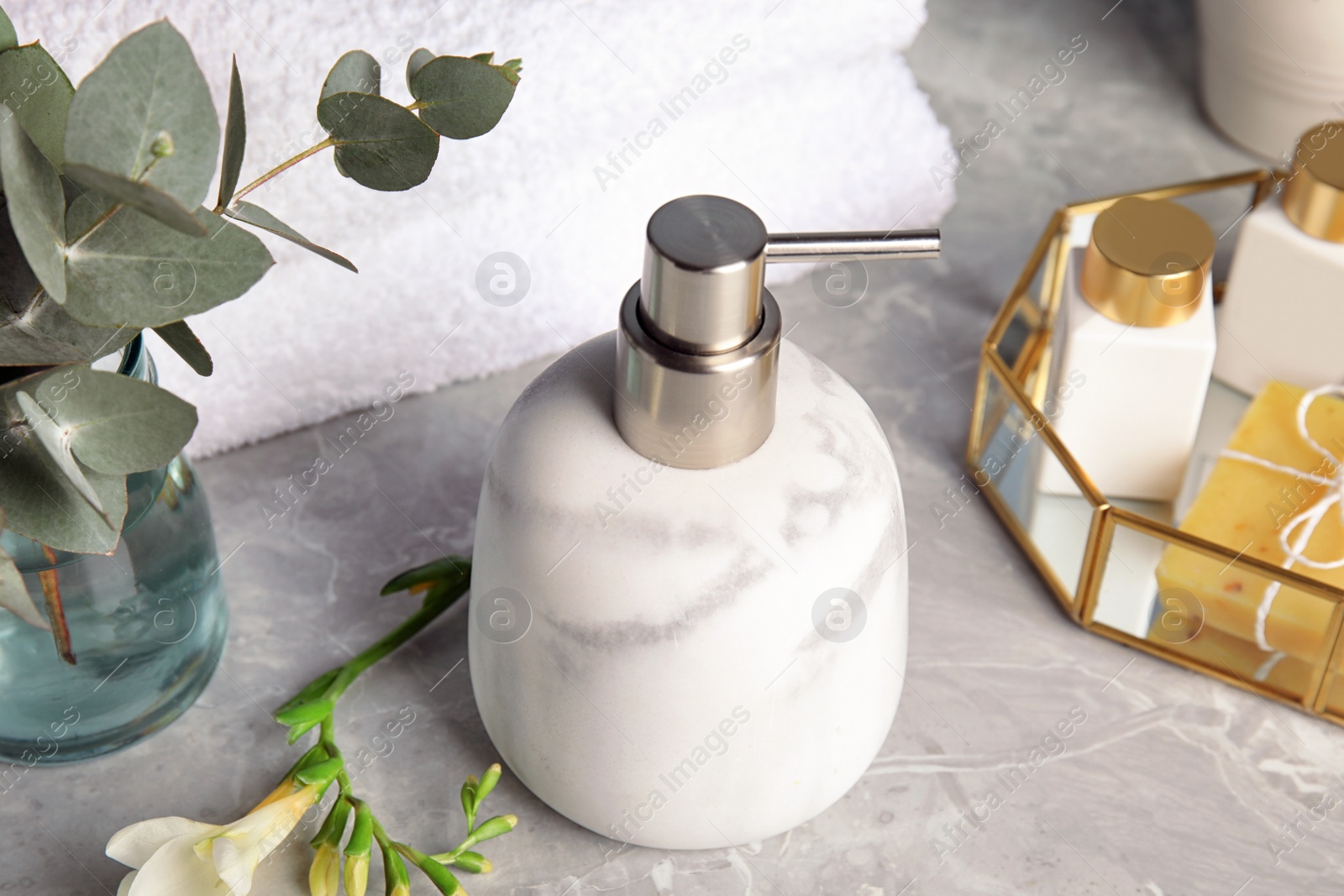 Photo of Marble soap dispenser and toiletries on grey table