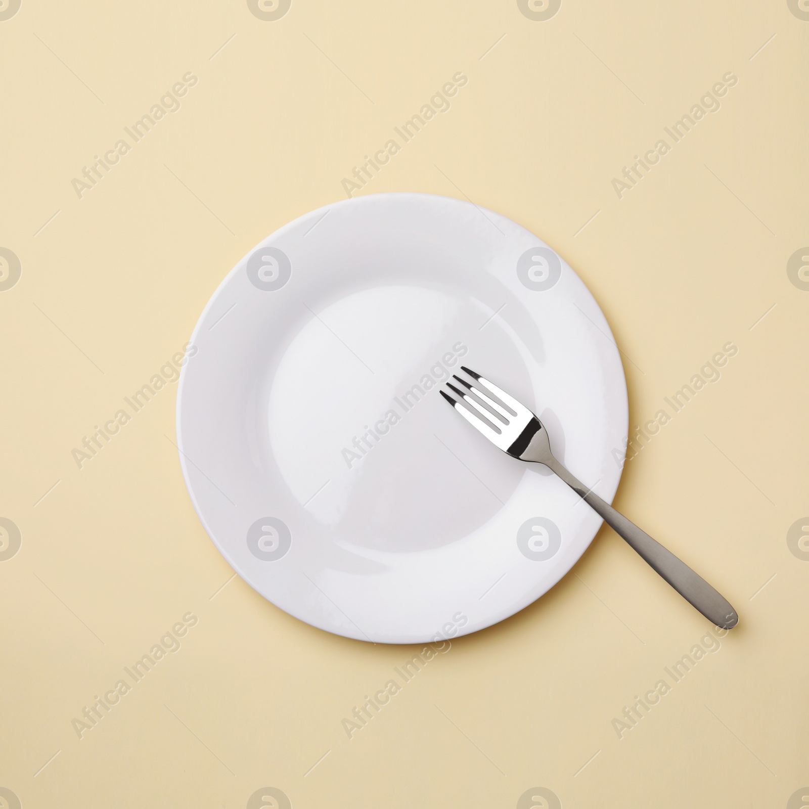 Photo of Empty plate and fork on color background, flat lay