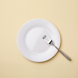 Photo of Empty plate and fork on color background, flat lay