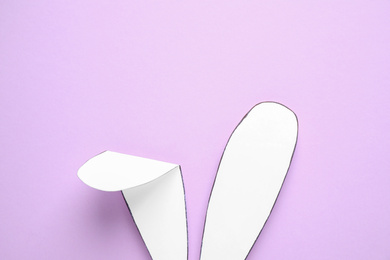 Photo of Top view of paper bunny ears on pale violet background. Easter celebration